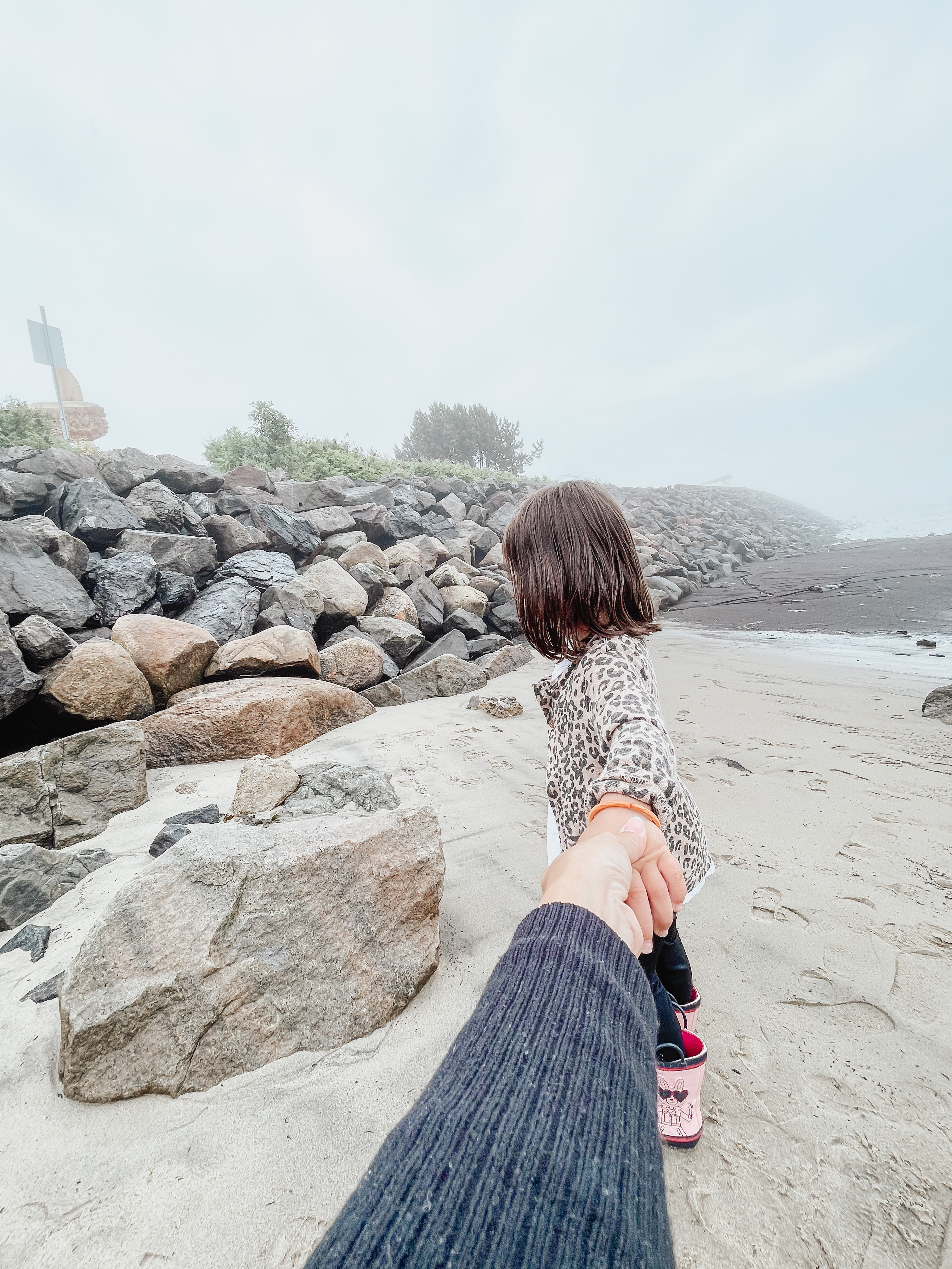 little girl holding hand at the beach