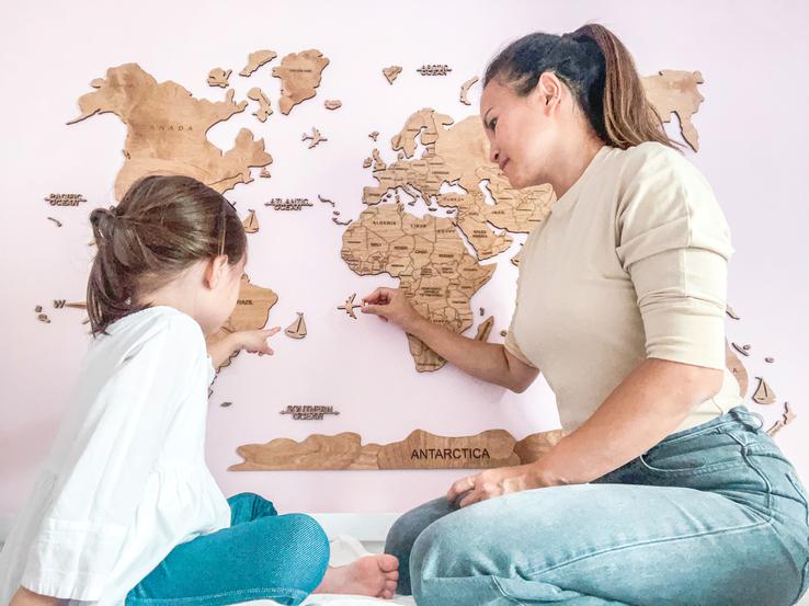 mom and daughter exploring the world map